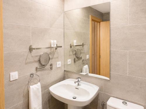 a bathroom with a sink and a mirror and a toilet at Hotel Musher in Pas de la Casa
