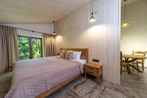a bedroom with a large bed and a table at Апарт- готель SunRay Skhidnytsya in Skhidnitsa