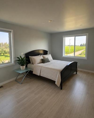 a bedroom with a large bed and two windows at Wonderful house in Niagara-on-the-Lake