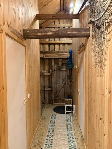 a hallway in a barn with wooden walls and a door at Skjellfjord cabin in Skjelfjord