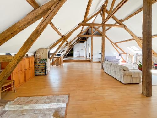 ein großes Wohnzimmer mit Holzbalken in der Unterkunft Chambre d'Hotes Cugnac in Sainte-Sabine