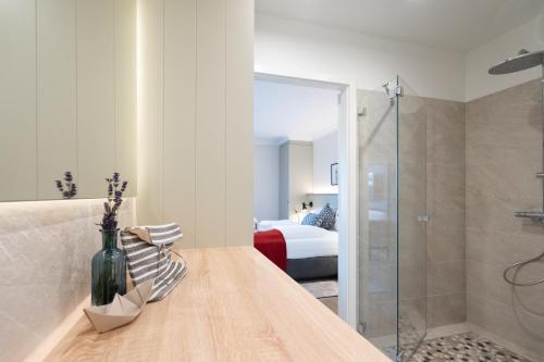 a bathroom with a glass shower and a bedroom at Apartmenthaus Resort Kranichsruh in Fuhlendorf