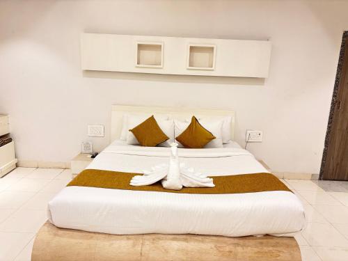 a bedroom with a large white bed with yellow pillows at The Byke Embassy - Surat in Surat