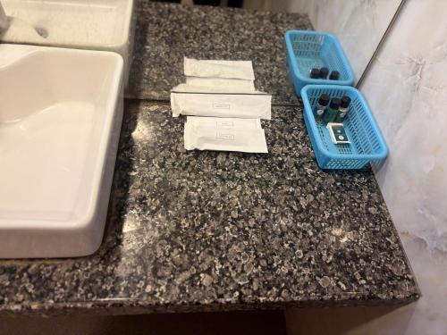 a bathroom counter with a sink and a blue basket at The Byke Embassy - Surat in Surat