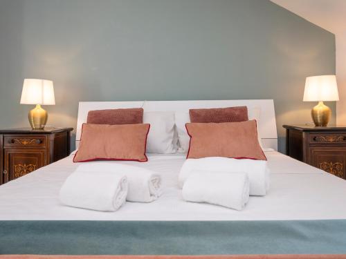 a white bed with two pillows and two lamps at NoLo Uptown Milano in Milan