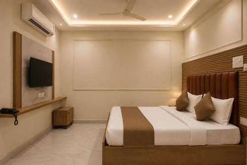 a bedroom with a bed and a flat screen tv at Hotel Vaarahi Chanda Nagar, Near Hitech City in Hyderabad