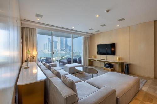 a living room with a couch and a tv at Vacationer Holiday Homes I Opulent 2 Bedroom I Sea View I Beach Access l FIVE Palm in Dubai