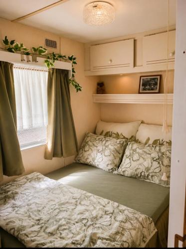 a bedroom with two beds and a window at Chatka w środku lasu in Czerwona Wola