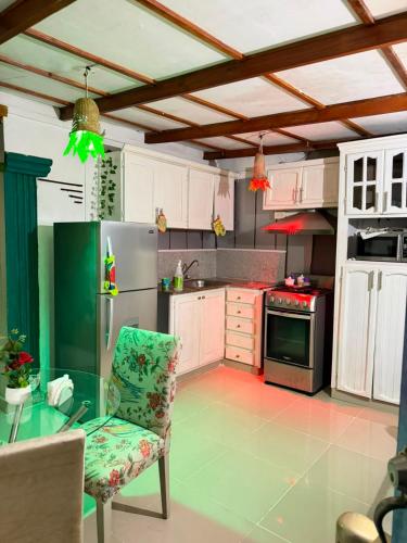 a kitchen with a glass table and a refrigerator at Valle Narural in Manoguayabo