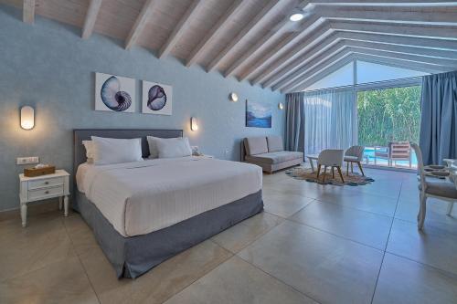a bedroom with a large bed and a living room at Ibiscus Corfu Hotel in Roda