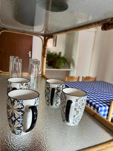 four blue and white cups sitting on a table at Riverfront Homestay in Port Elizabeth