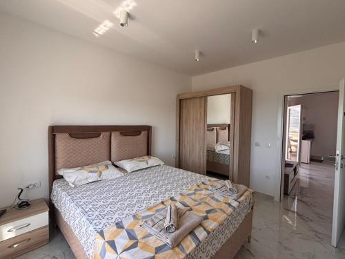a bedroom with a large bed and a mirror at Apartments Nahla in Bar