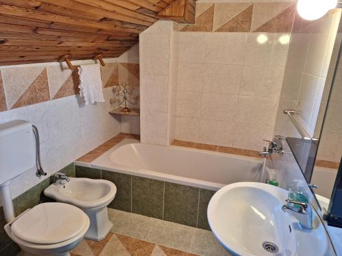 a bathroom with a sink and a toilet and a tub at David Linea House in Volavlje