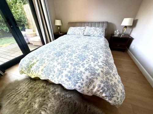 a bedroom with a bed with a blue and white comforter at Oak Lodge in Hambledon
