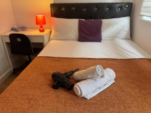 a bedroom with a bed with towels and a camera at Cosy Private Bedrooms in Euston Station in London