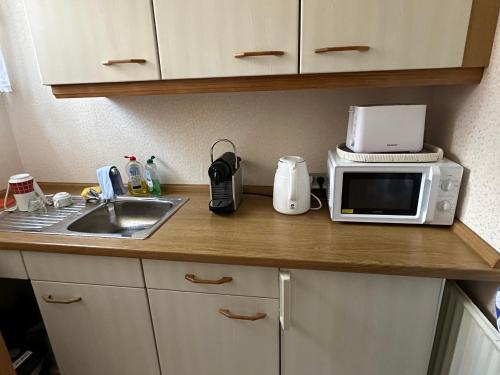 a kitchen counter with a microwave and a sink at Pension Katharina im Solling in Holzminden