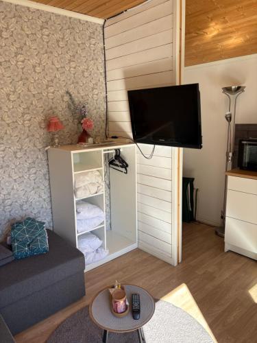 a living room with a tv and a couch at Söt stuga in Strömstad