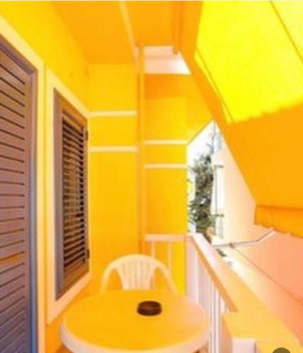 a yellow room with a yellow table and a window at Gregor Villa in Asim Zeneli
