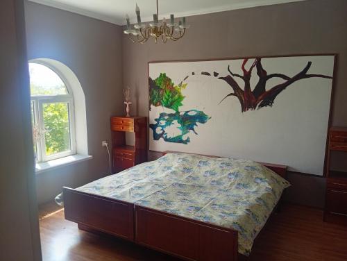 a bedroom with a bed and a painting on the wall at Дом in Shorzha