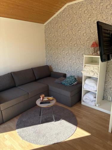 a living room with a couch and a table at Söt stuga in Strömstad