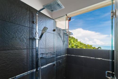 a bathroom with a shower with a view of the ocean at The View in Ban Tai