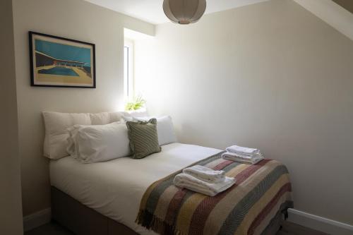 a bedroom with a bed with a blanket on it at The Yard Dungarvan in Dungarvan
