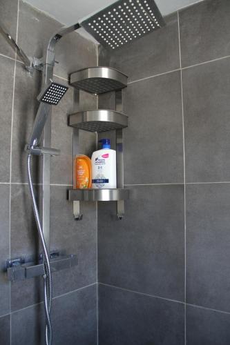 a bathroom with a shower with a shower head at Cosy Private Bedrooms in Euston Station in London