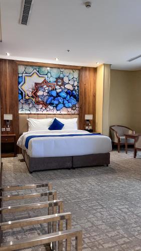a bedroom with a large bed with a painting on the wall at Lanai Hotel فندق لاناي in Jeddah