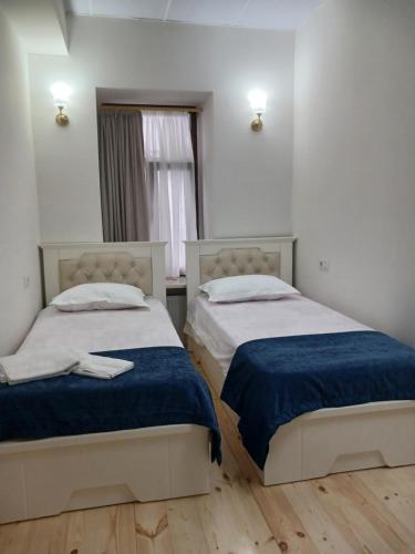 two beds in a small room with a window at Hotel White Neptun Georgia Tbilisi in Tbilisi City