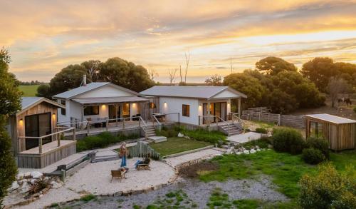 a woman standing in front of a house at The Sanctuary at Bayside Glamping in Marion Bay