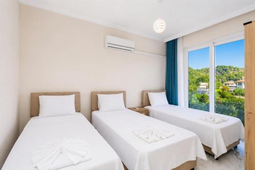 two beds in a room with a window at Villa Azalea 2 in Ortaca