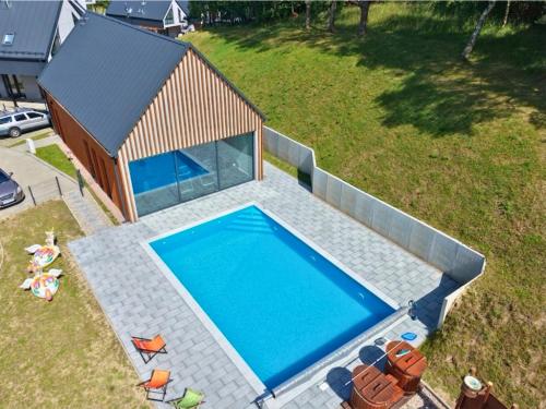 an overhead view of a swimming pool in front of a house at Domek Reset Kaszuby - Basen, Jacuzzi, Sauna, Siłownia in Łączyno