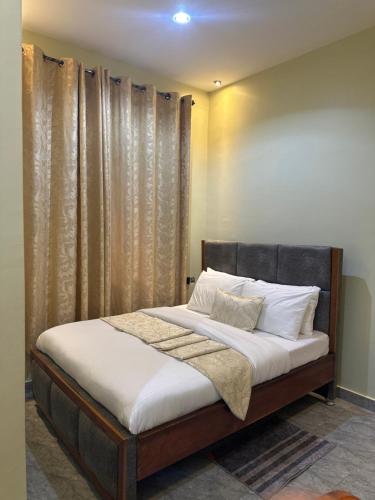 a bed with white sheets and pillows in a bedroom at Ecostar apartments in Morogoro