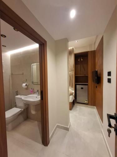 a bathroom with a white toilet and a sink at ReLax havanaa in Cairo