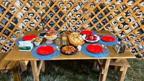 a picnic table with plates of food on it at BooGoo yurt camp in Song-Kul