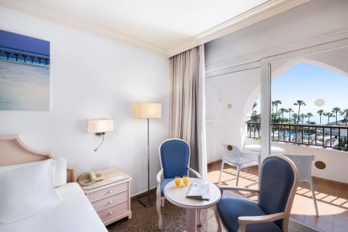 a hotel room with a bed and a table and chairs at Mac Puerto Marina Benalmádena in Benalmádena