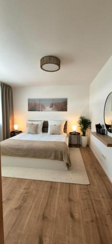a bedroom with a large bed and wooden floors at Apartment Illerblick in Dettingen an der Iller