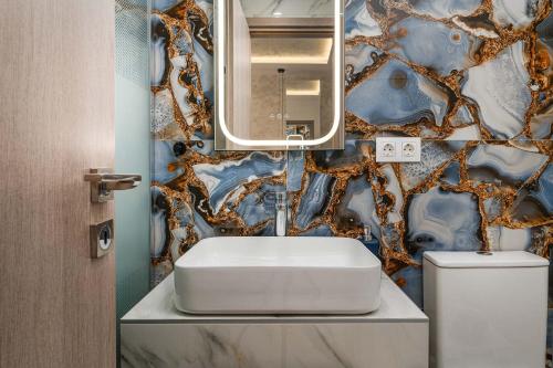 a bathroom with a sink and a mirror and a toilet at Kreka Apartments in Pefkochori