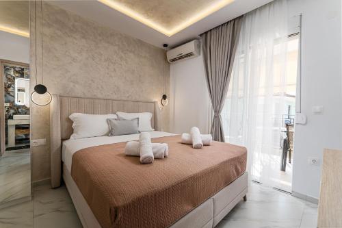 a bedroom with a large bed with towels on it at Kreka Apartments in Pefkochori