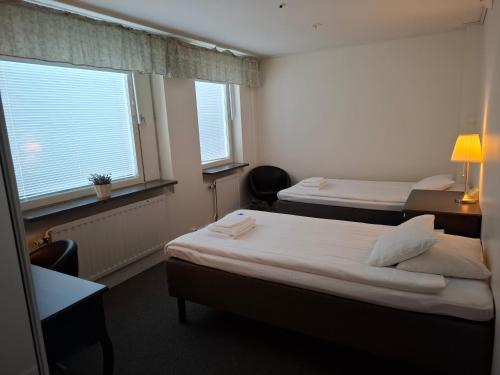a hotel room with two beds and two windows at STF Luleå Gammelstad Hostel in Nederluleå