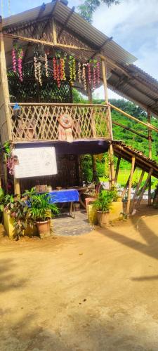 a pavilion with a blue bench and potted plants at ChangGhor in Digru