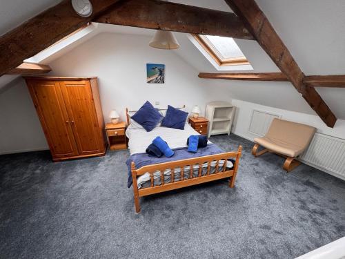 a bedroom with a bed with blue pillows at Central Spacious 3 Bed Cottage, Sleeps 5 in Tenby