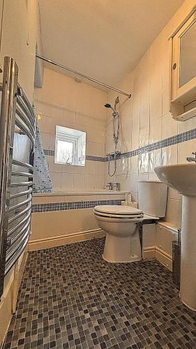 a bathroom with a toilet and a sink at Central Spacious 3 Bed Cottage, Sleeps 5 in Tenby