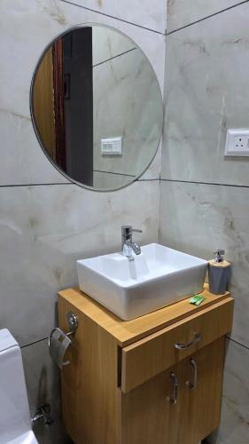 a bathroom with a sink and a mirror at 4j Aravalli Farms in Dhauj