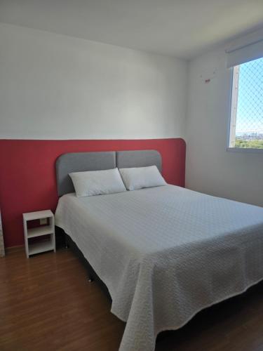 a bed in a bedroom with a red and white wall at Bem-vindo ao seu refúgio em Palhoça in Palhoça