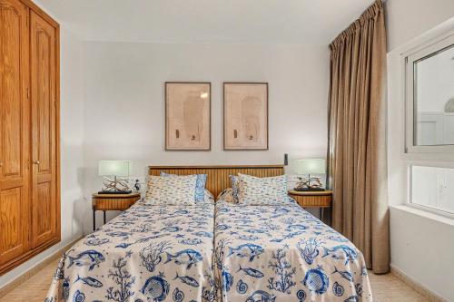 a bedroom with a bed with a blue and white bedspread at Callao Beach 5 in Arrieta