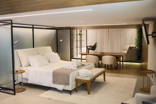 a bedroom with a bed and a dining room at Hotel Pedra Negra Gov. Valadares in Governador Valadares