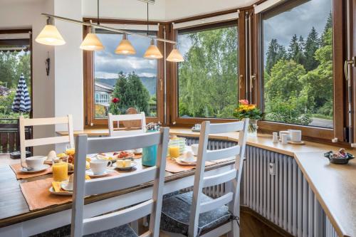 a dining room with a table and chairs and windows at Friedolin im Bärenhüsli in Titisee-Neustadt