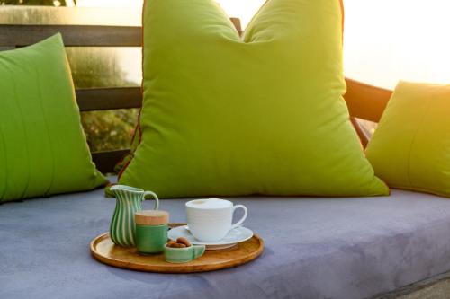 a tray with a cup of coffee on a bed at Nakai Beach Homestay in Trafalgar