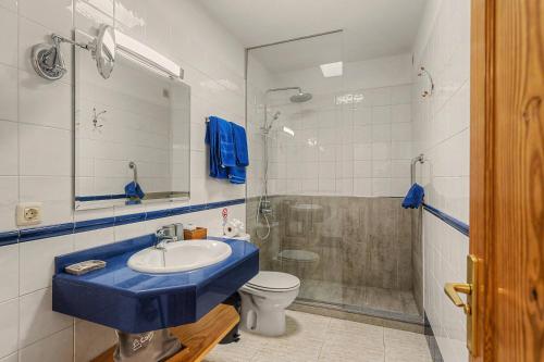 a bathroom with a blue sink and a shower at Callao Beach 10 in Arrieta
